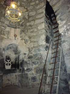 Eine steile Leiter führt tief hinab in das Verlies des Heiligen Gregors