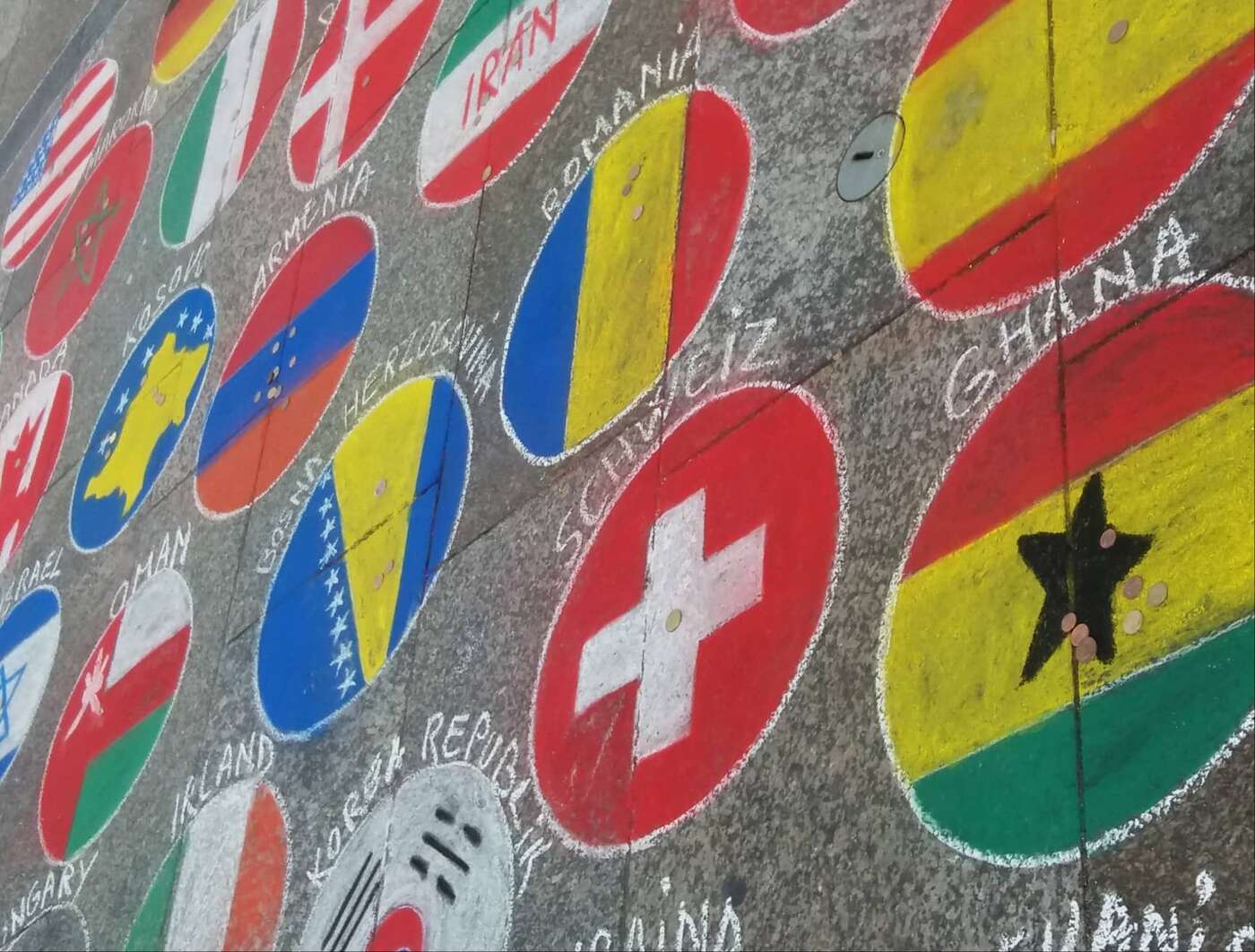 A photograph of flags drawn in chalk on the ground near Cologne cathedral.