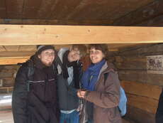 Drei Freiwillige in einem traditionellen Holzhaus. Gut, dass die heutigen Decken etwas höher sind!