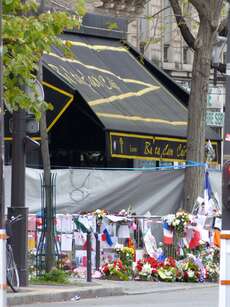 Vor der Konzerthalle "Bataclan", in der allein 89 Menschen ihren Tod fanden, haben Trauernde Blumen, Flaggen und Bilder zum Gedenken hingelegt.