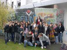 Jugendliche besprühen die Mauer von BERLINiort